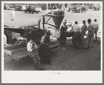 Farmers around agricultural machine, Jacksonville, Texas