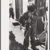 Mexican migrant boy drinking out of water hose at filling station where the truck which is taking him home from Mississippi where he has been picking cotton has stopped. Neches, Texas