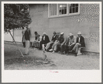 Men sitting on a bench at county fair, Gonzales, Texas