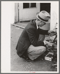 Man looking at wrench. Market square, Waco, Texas
