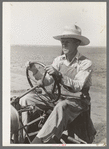 Day laborer at wheel of tractor on large farm near Ralls, Texas