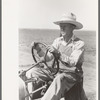 Day laborer at wheel of tractor on large farm near Ralls, Texas