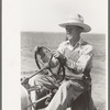 Day laborer at wheel of tractor on large farm near Ralls, Texas