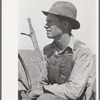 Day laborer sitting in tractor seat, large farm near Ralls, Texas