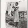 Daughter of tenant farmer hanging up clothes near Warner, Oklahoma