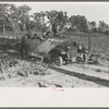 Pushing a car belonging to agricultural day laborer to start it, near Muskogee, Muskogee County, Oklahoma