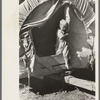 Son of white migrant stepping from covered wagon-type trailer, Wagoner County, Oklahoma