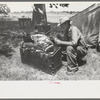 Veteran migrant agricultural worker examining contents of his trunk, camped on Arkansas River in Wagoner County, Oklahoma