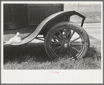 Detail of automobile of white migrant family with sack of salt on running board and leather-laced tire, Fort Gibson, Oklahoma