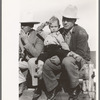 West Texan and his son sitting on fence at horse auction, El Dorado, Texas