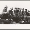 West Texans sitting on fence at horse auction. El Dorado, Texas