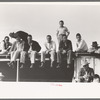 West Texans sitting on top of grandstand roof at horse auction. El Dorado, Texas