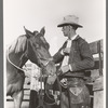 Cattleman with his horse at auction, San Angelo, Texas