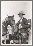 Cattleman with his horse at auction, San Angelo, Texas