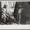 Pomp Hall, Negro tenant farmer, talking to another farmer as he waits at the blacksmith shop in Depew, Oklahoma for his plow points to be sharpened