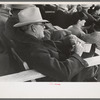 Spectator checking time of the calf ropers at the rodeo at the San Angelo Fat Stock Show, San Angelo, Texas