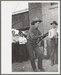 Member of orchestra which plays outside grocery store on Saturday afternoon tuning his violin, Phoenix, Arizona