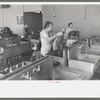 Wives of migratory workers in the laundry room at the Agua Fria Migratory Labor Camp, Arizona. Hot and cold water are furnished by the camp, soap and other washing materials by the people