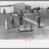 Worker mowing grass at the Agua Fria Migratory Labor Camp, Arizona