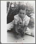 Little girl playing jacks at the Casa Grande Valley Farms, Pinal County, Arizona