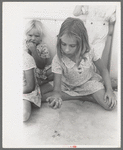 Little girl playing jacks at the Casa Grande Valley Farms, Pinal County, Arizona