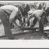 Judges inspecting drill which will be used in miners power drilling contest at Labor Day celebration, Silverton, Colorado