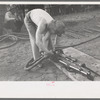 Miner attaching airhose to power drill which he will use in drilling contest, Labor Day celebration, Silverton, Colorado