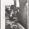 Covering a plate of barbecue sandwiches with another plate to protect the food from the rain, Labor Day at Ridgeway, Colorado