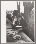 Covering a plate of barbecue sandwiches with another plate to protect the food from the rain, Labor Day at Ridgeway, Colorado