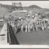 Construction workers using tools to settle freshly-poured concrete, Shasta Dam, Shasta County, California