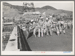 Construction workers using tools to settle freshly-poured concrete, Shasta Dam, Shasta County, California