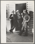 Shasta Dam construction workers drinking beer at entrance to bar, Central Valley, California