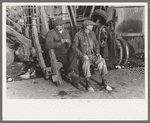 Men sitting on parts of truck in junkyard, South Side of Chicago, Illinois