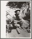John Adams, homesteader, resting on homemade vehicle on which he is hauling ties down mountain, Pie Town, New Mexico