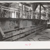 Large tanks used for mixing powdered gold ore with cyanide solution to extract gold and silver, gold mine, Mogollon, New Mexico