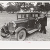 Mr. Bill Stagg putting container of food which was left from dinner at the community sing back into the car, Pie Town, New Mexico