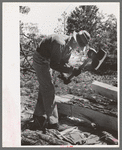 Using a broad axe in hewing ties, Pie Town, New Mexico