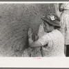 After plaster is applied with towel it is smoothed out with the hands. The women pride themselves on careful plastering, Chamisal, New Mexico
