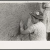 After plaster is applied with towel it is smoothed out with the hands. The women pride themselves on careful plastering, Chamisal, New Mexico