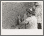 After plaster is applied with towel it is smoothed out with the hands. The women pride themselves on careful plastering, Chamisal, New Mexico
