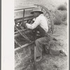 Mormon farmer working on FSA (Farm Security Administration) cooperative drill, Oneida County, Idaho. While the members of the cooperative live in Snowville, Utah, some of them farm in Oneida County, Idaho