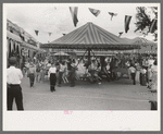 Old merry-go-round at Taos, New Mexico, during fiesta. This is reputed to be the oldest merry-go-round in America