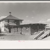 Delta County, Colorado. Home and old log cabin on a peach grower's farm. This man came from Oklahoma determined never again to dry land farm; his peaches are irrigated. He was fortunate in finding a place to rent from a farmer who was very old and wanted