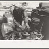 Farm worker at work on his automobile. FSA (Farm Security Administration) Labor Camp, Caldwell, Idaho