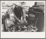 Farm worker at work on his automobile. FSA (Farm Security Administration) Labor Camp, Caldwell, Idaho