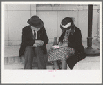 Farmer and his wife write a letter on the post office steps, Ontario, Oregon