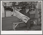 Resident of Funkley, Minnesota, reading newspaper in general store