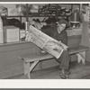 Resident of Funkley, Minnesota, reading newspaper in general store