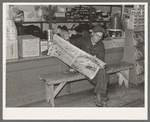 Resident of Funkley, Minnesota, reading newspaper in general store