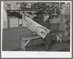 Resident of Funkley, Minnesota, reading newspaper in general store